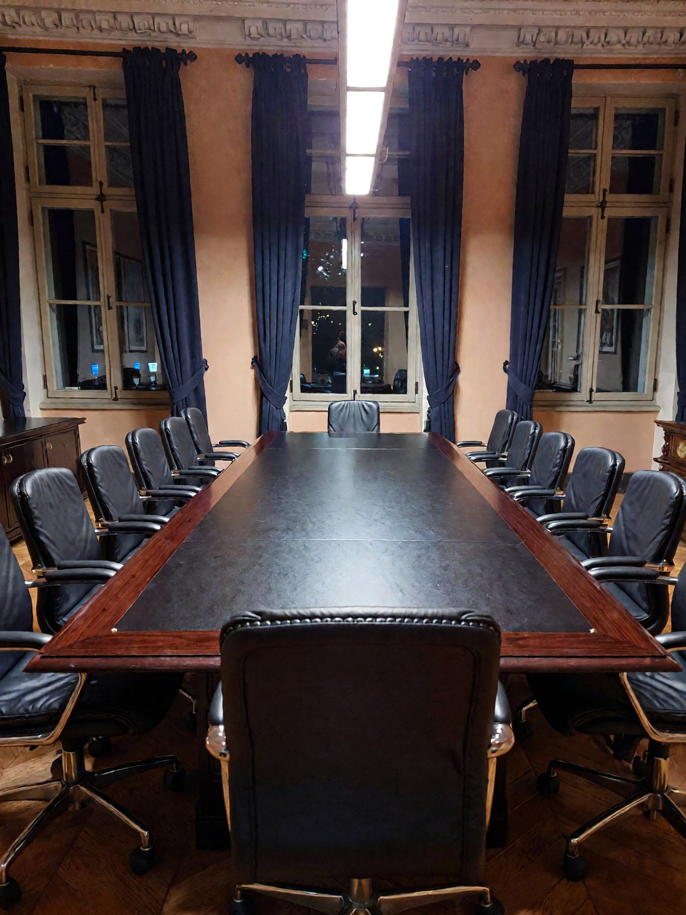 Empty boardroom at night with light across the table