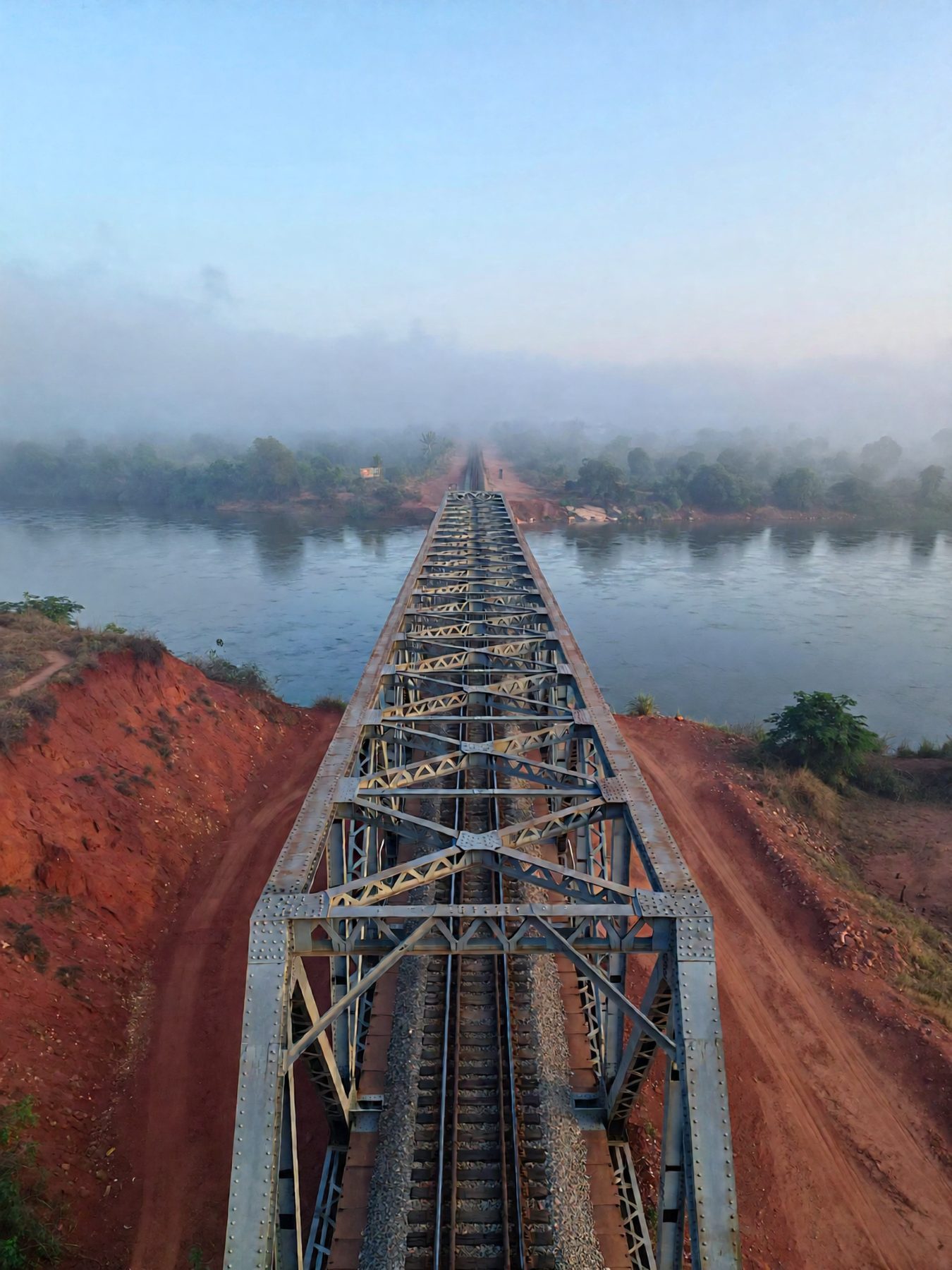 Railway bridge crossing a river valley in West Africa at dawn
